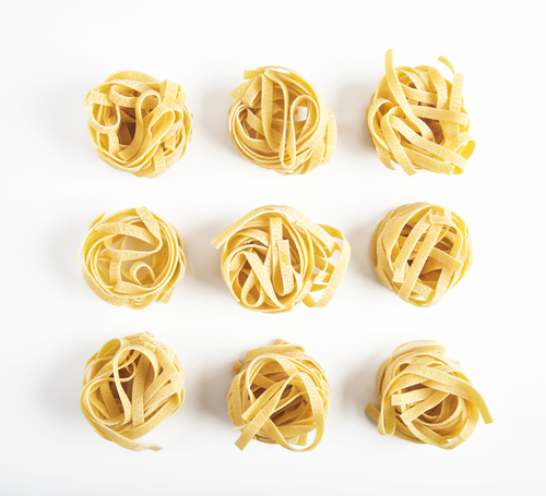 Passover potato starch noodle illustration: dried pasta coils against white backdrop