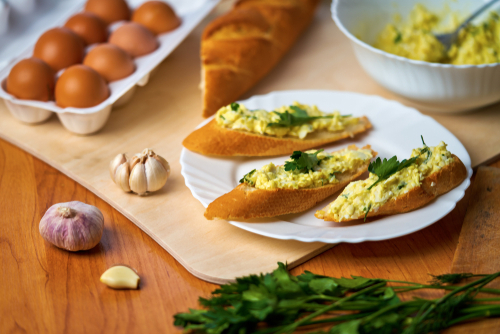 Eggs and onion on a slice of baguette garnished with parsley