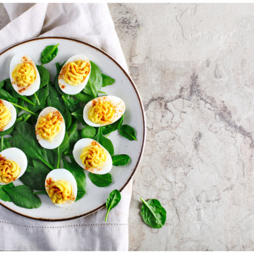 deviled eggs on plate lined with greens