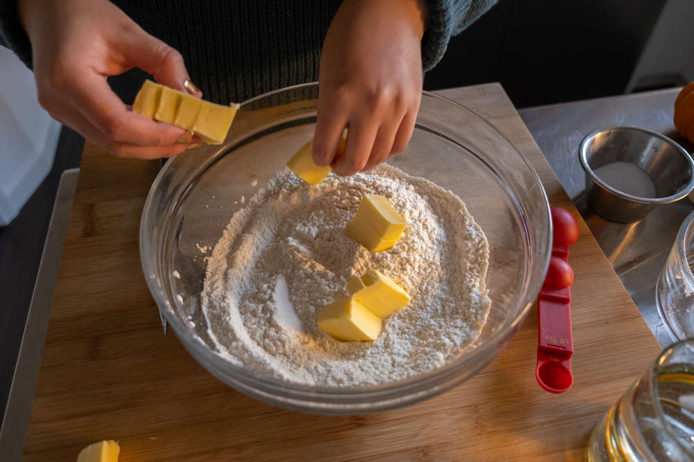 cutting pieces of butter into flour